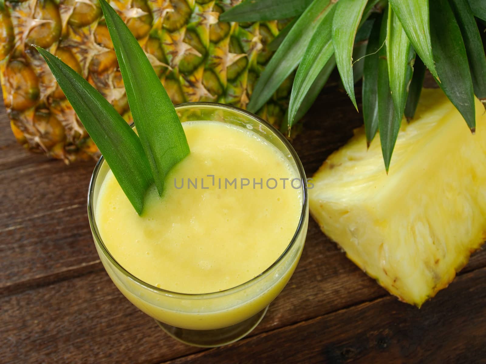 pineapple juice and pineapple on wood table. for health
