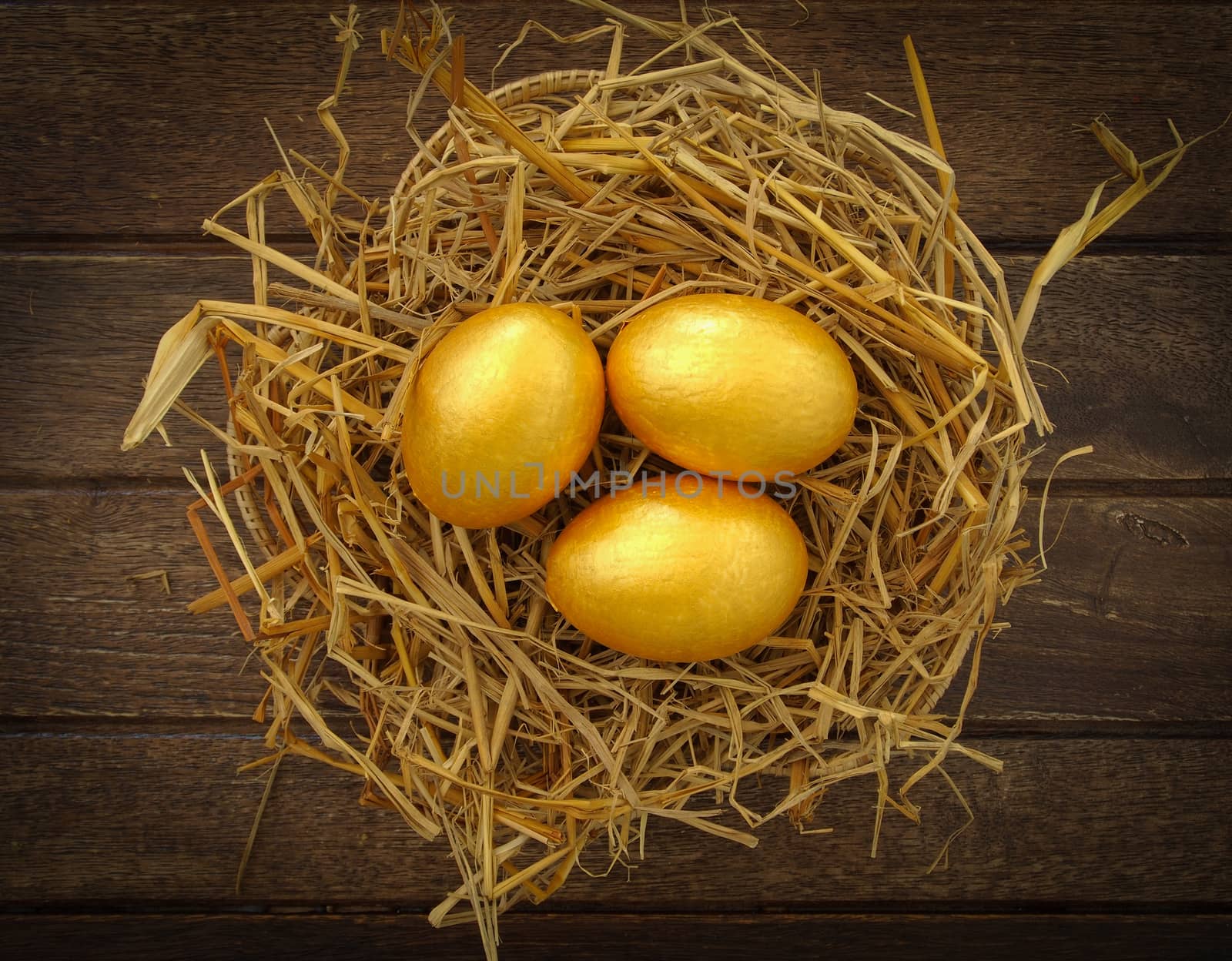 gold eggs in nest on wood background ,business concept