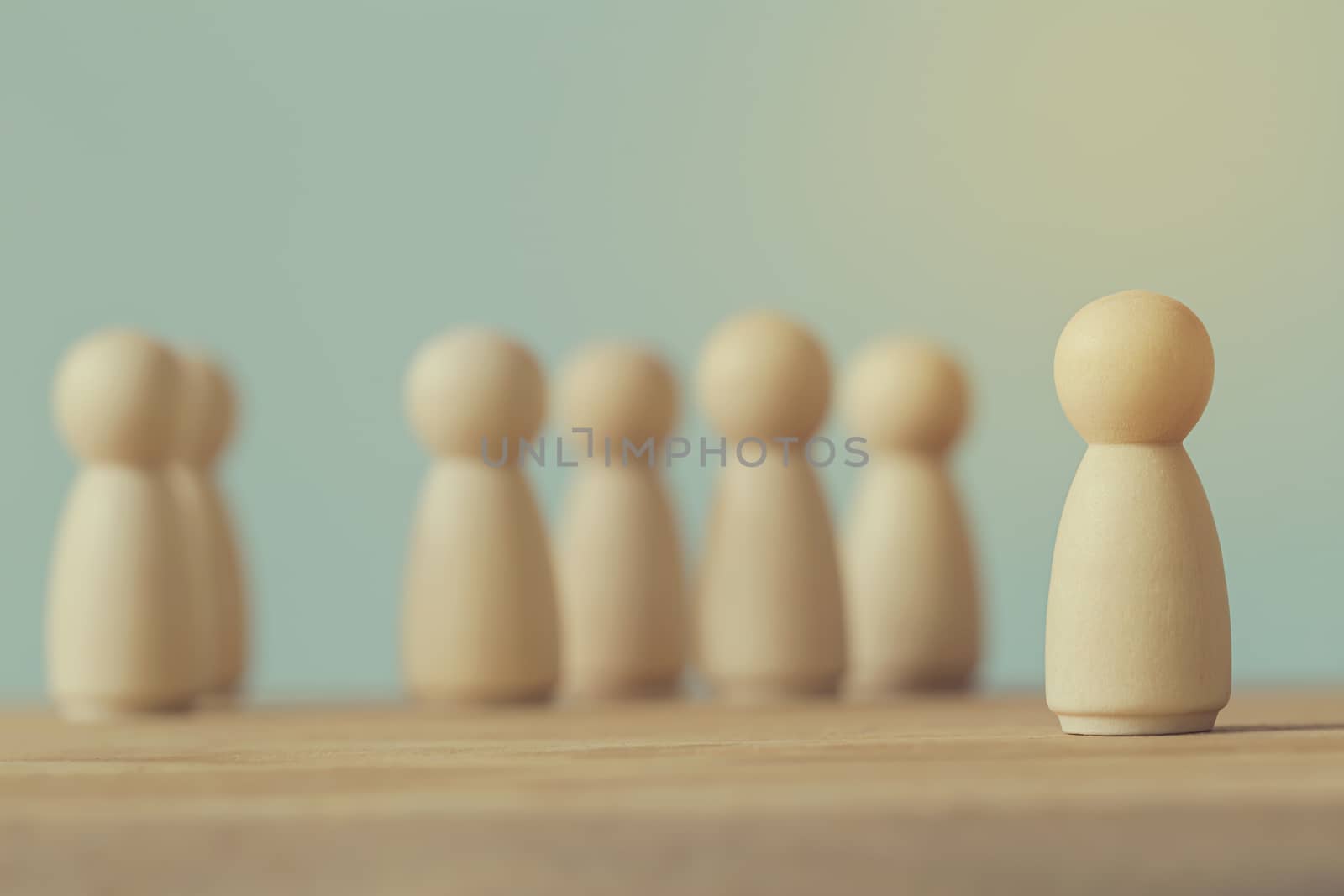 Successful business team leader concept: Wooden figures of man and people standing out from the crowd. depicts human Resource management and recruitment employee or hiring.