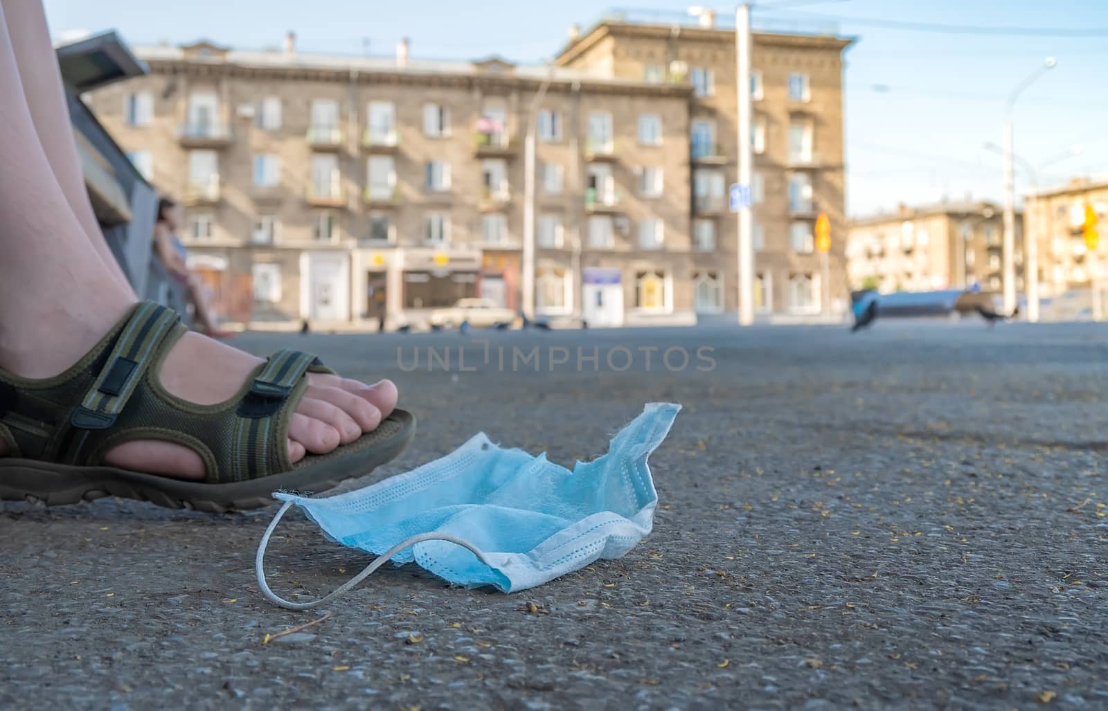 used antibacterial medical mask lies on the asphalt by jk3030