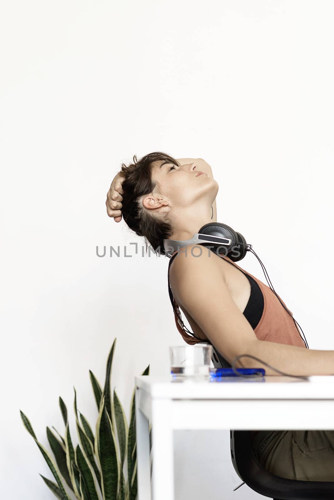 Young freelancer woman stretching at home workplace