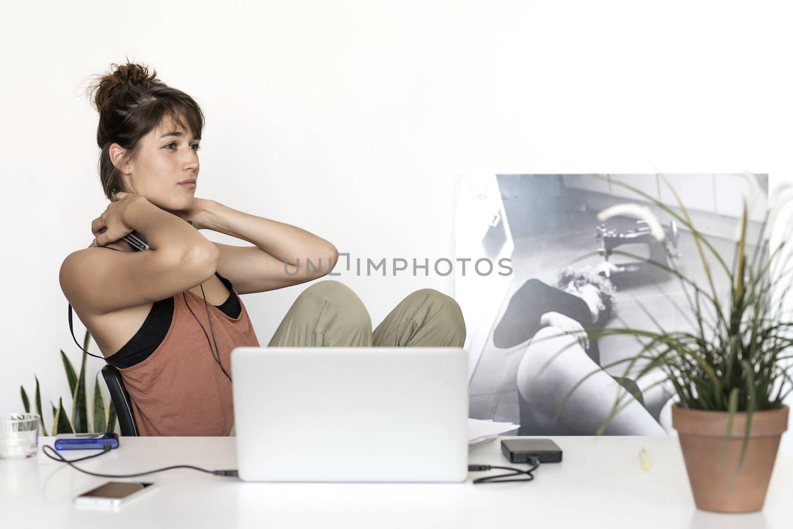Young freelancer woman stretching at home workplace