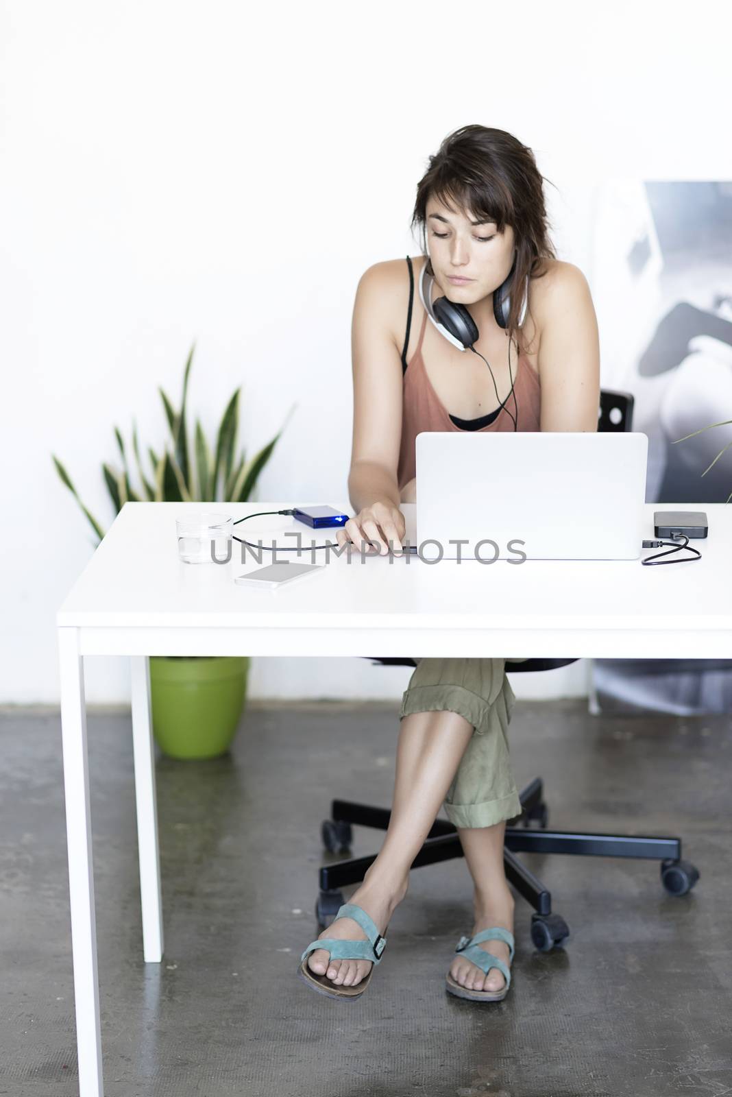 Portrait of a young happy woman sitting at desk, working on computer at home