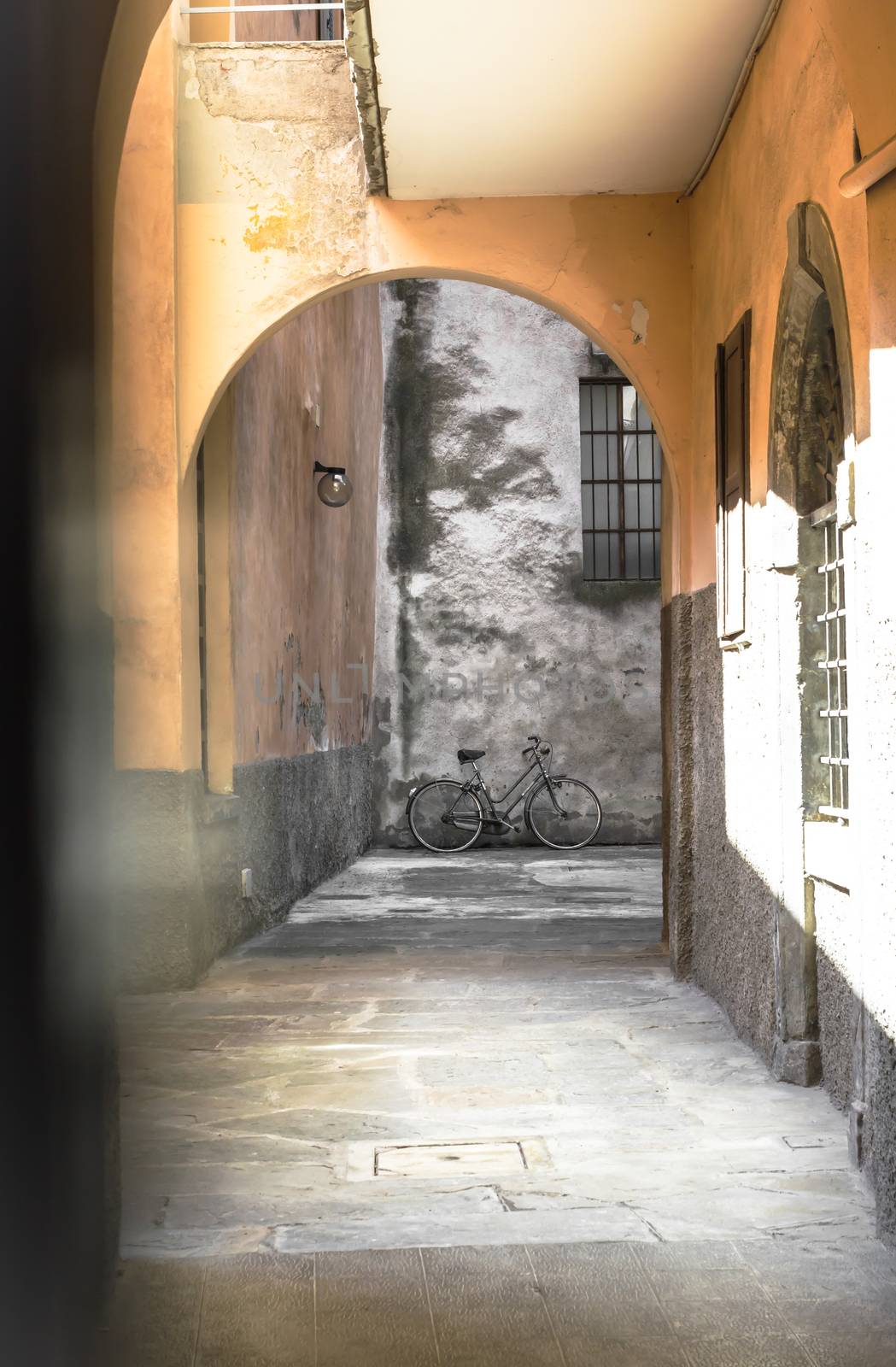 Old backyard of house with archway and vintage bicycle. Shallow DOF.