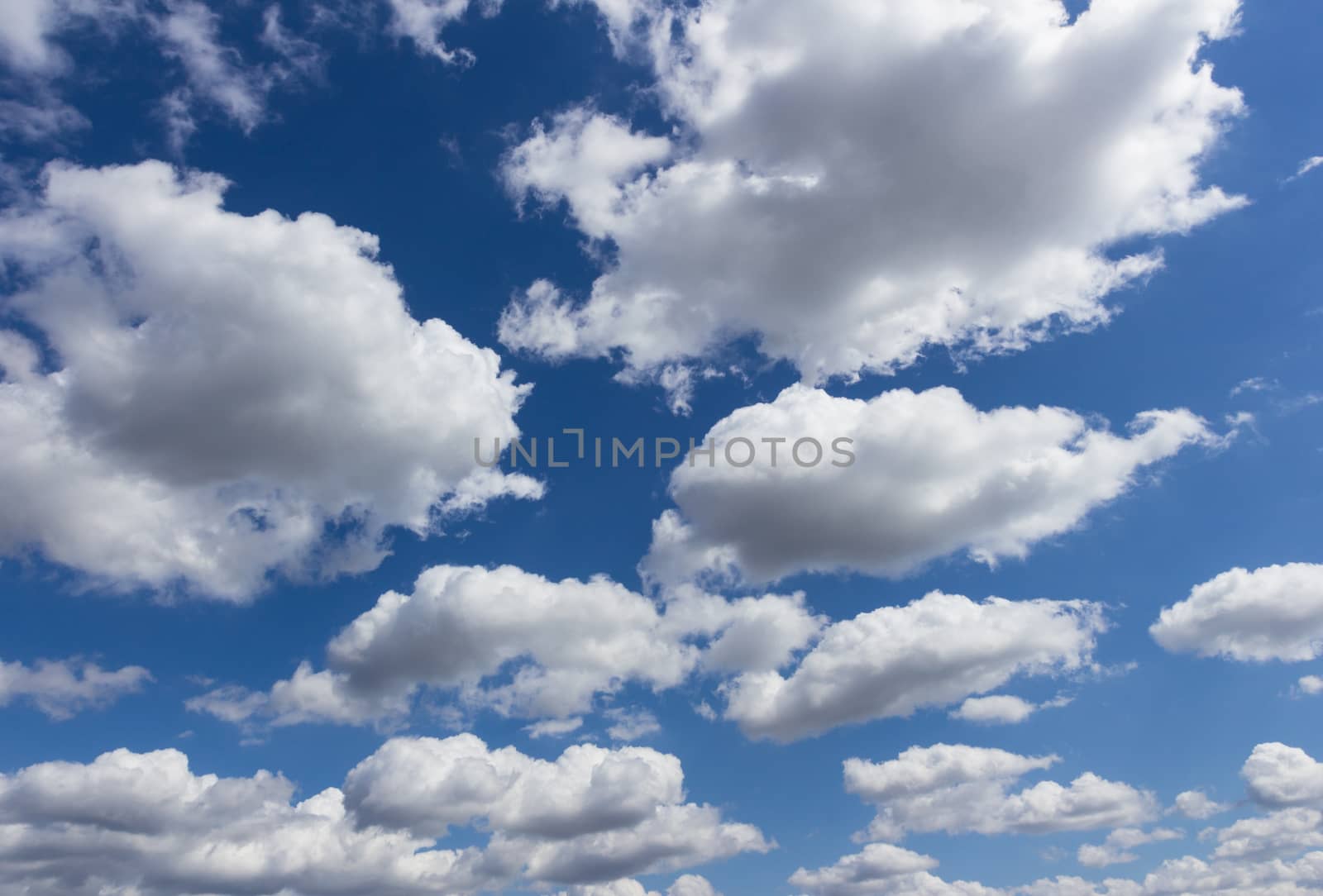 Cloudy blue sky. Numerous white and gray clouds