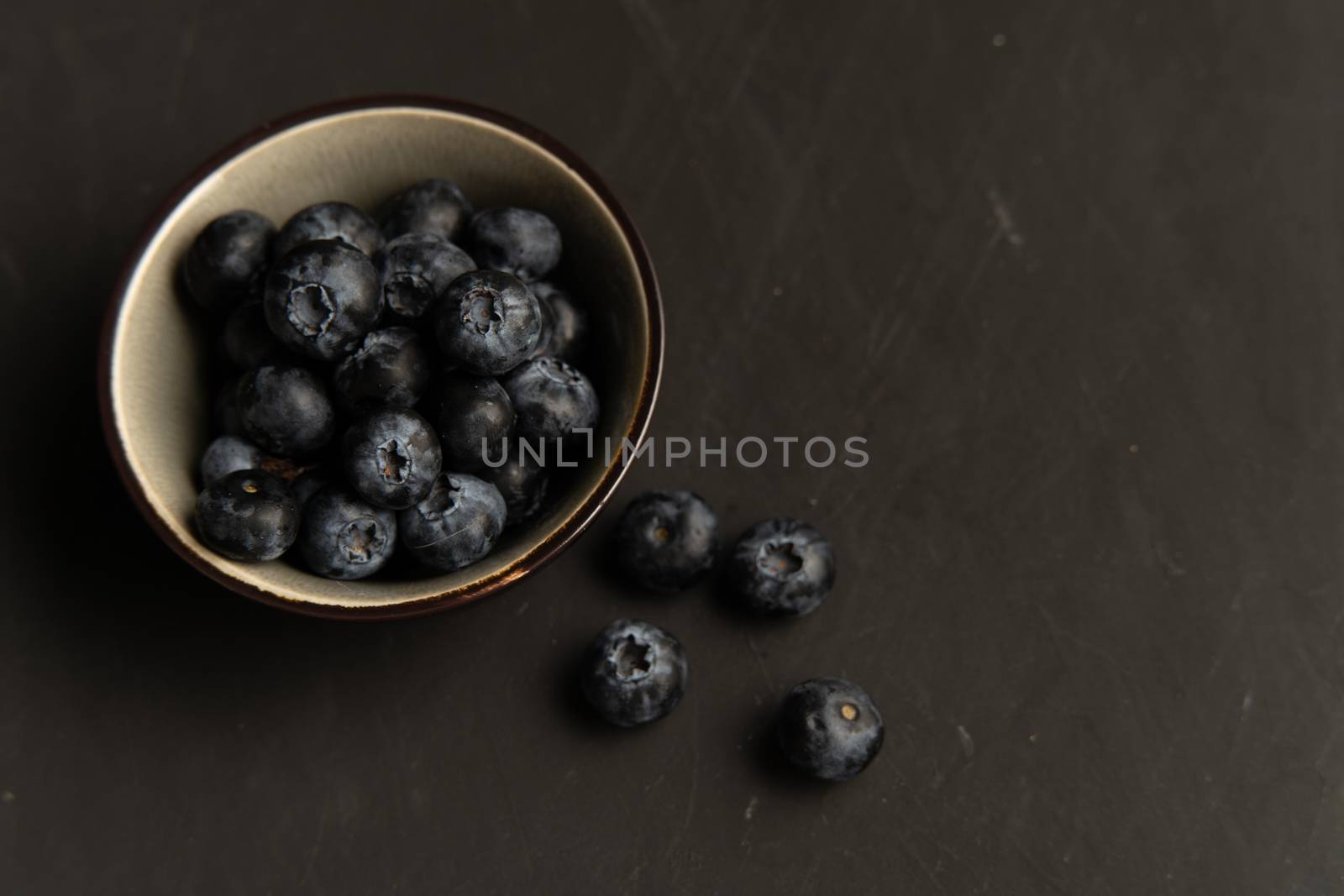 Blueberry antioxidant organic superfood in ceramic bowl concept for healthy eating and dieting nutrition Top view on dark black background