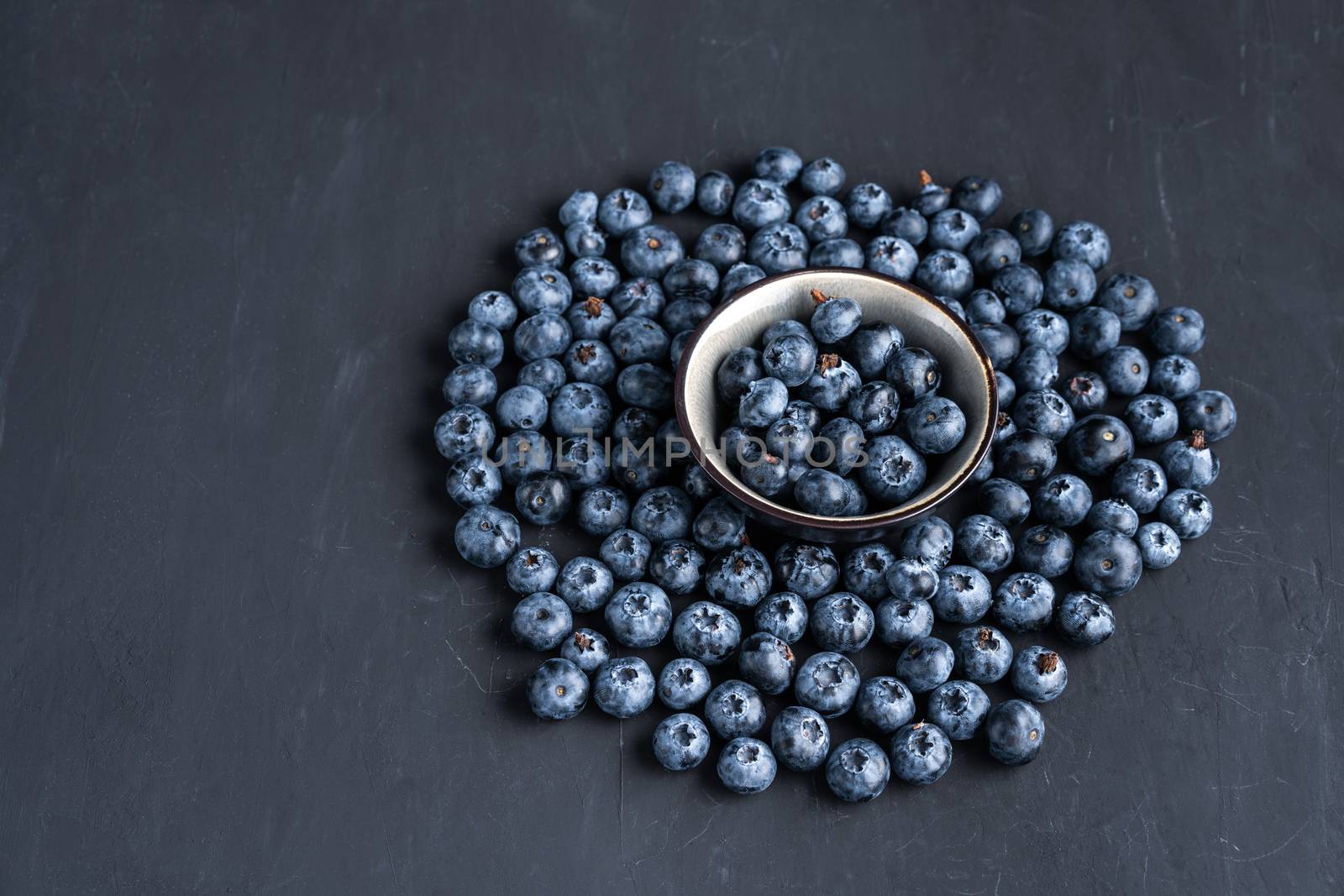Blueberry antioxidant organic superfood in ceramic bowl concept for healthy eating and dieting nutrition Top view on dark black background