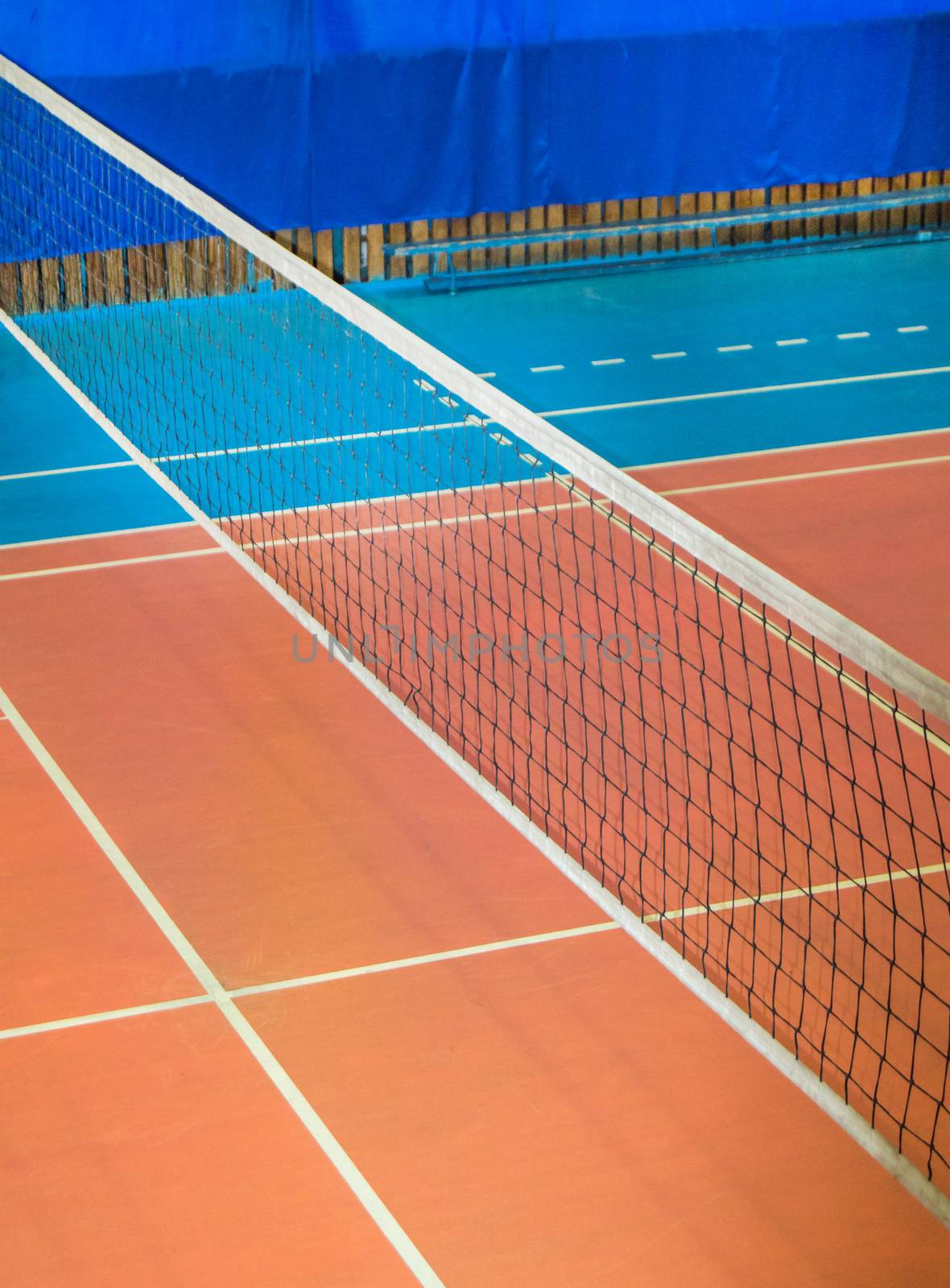 Modern empty school gym indoor with volleyball net, vertical frame.