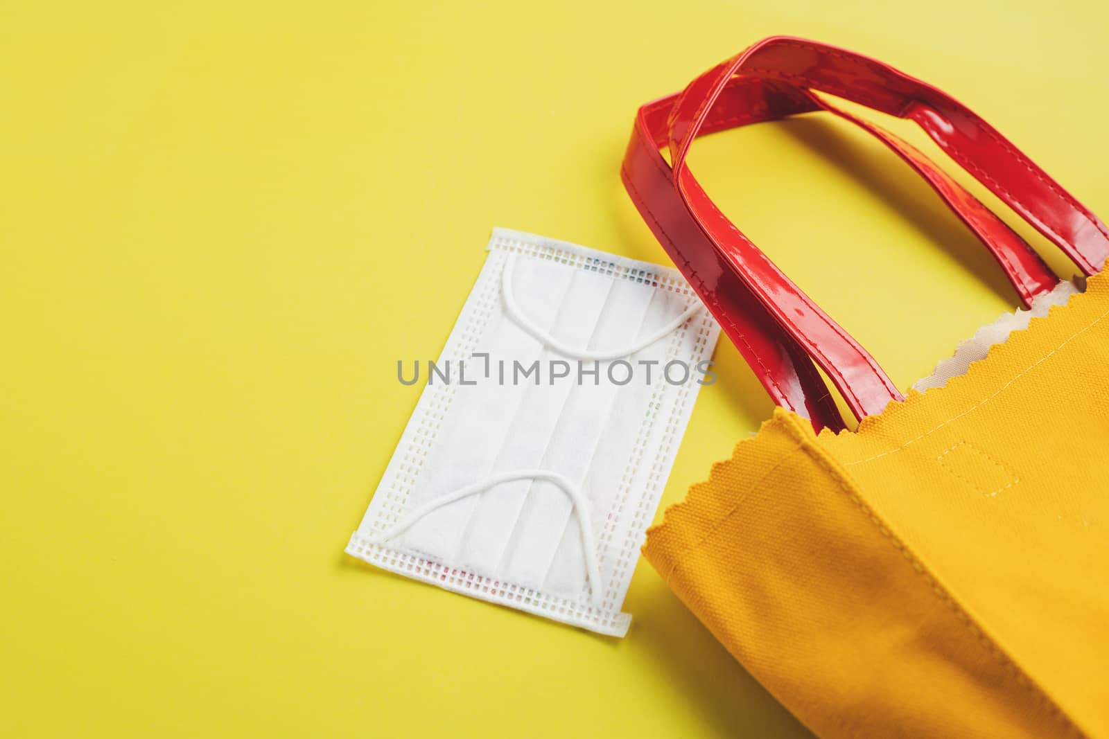 Hygiene face mask with shopping bag on yellow background for healthcare and new normal or new way of living concept