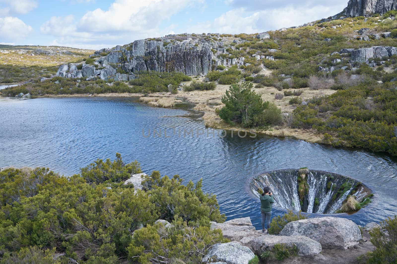 Woman girl taking photos of Covao dos Conchos lagoon in Serra da Estrela, Portugal by Luispinaphotography