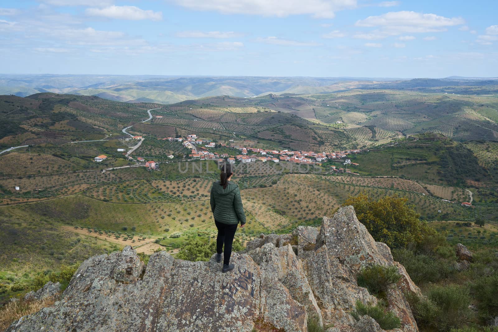 Woman social distancing looking at Castelo Melhor aerial view from miradouro de Sao Gabriel viewpoint