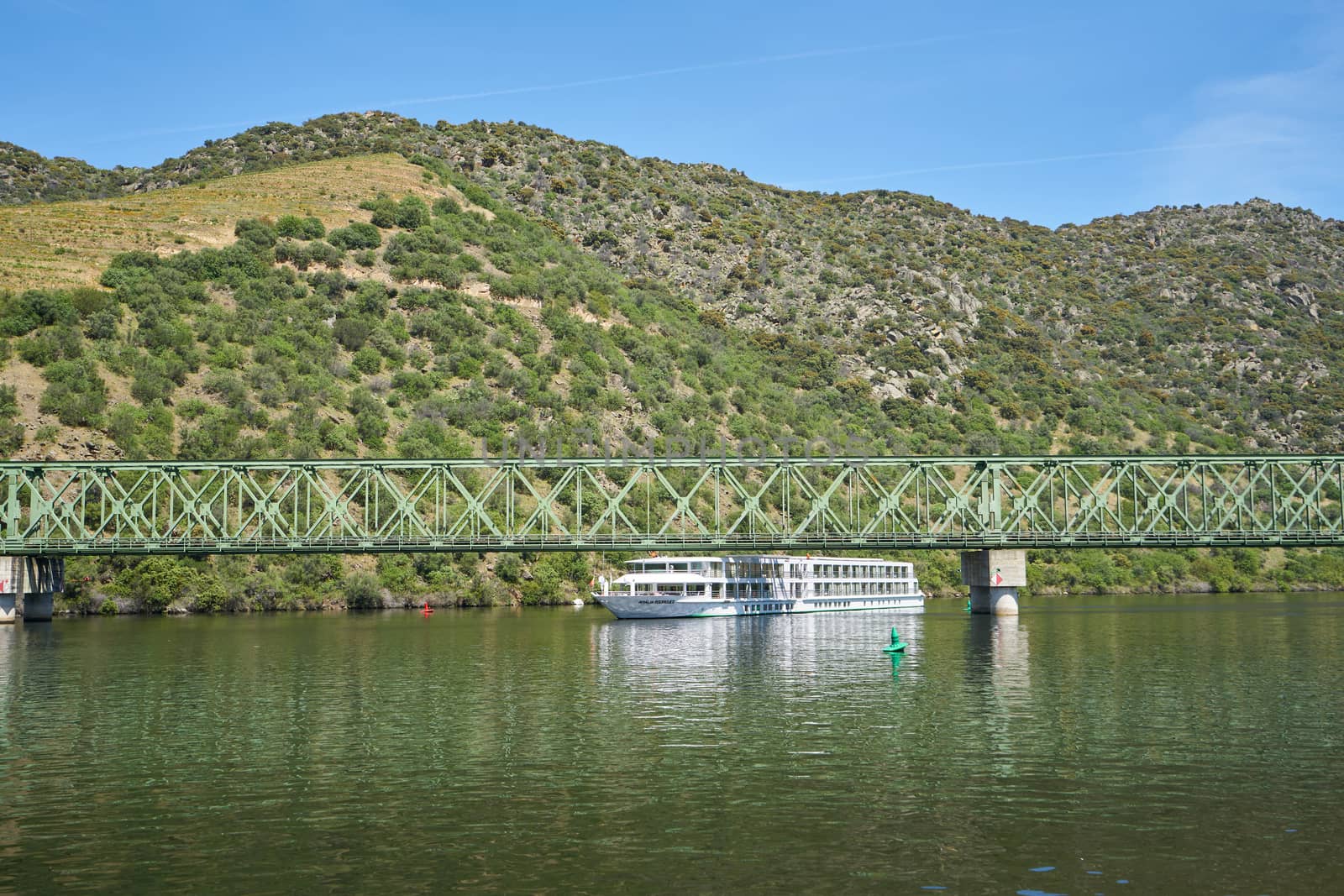 Boats passing on railway bridge in Douro region in Ferradosa, Portugal by Luispinaphotography