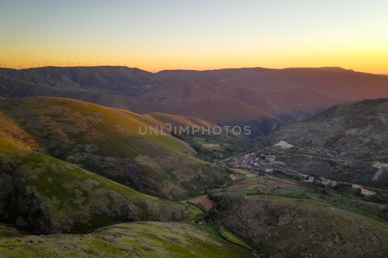 Serra da Freita drone aerial view in Arouca Geopark road with wind turbines at sunset, in Portugal by Luispinaphotography