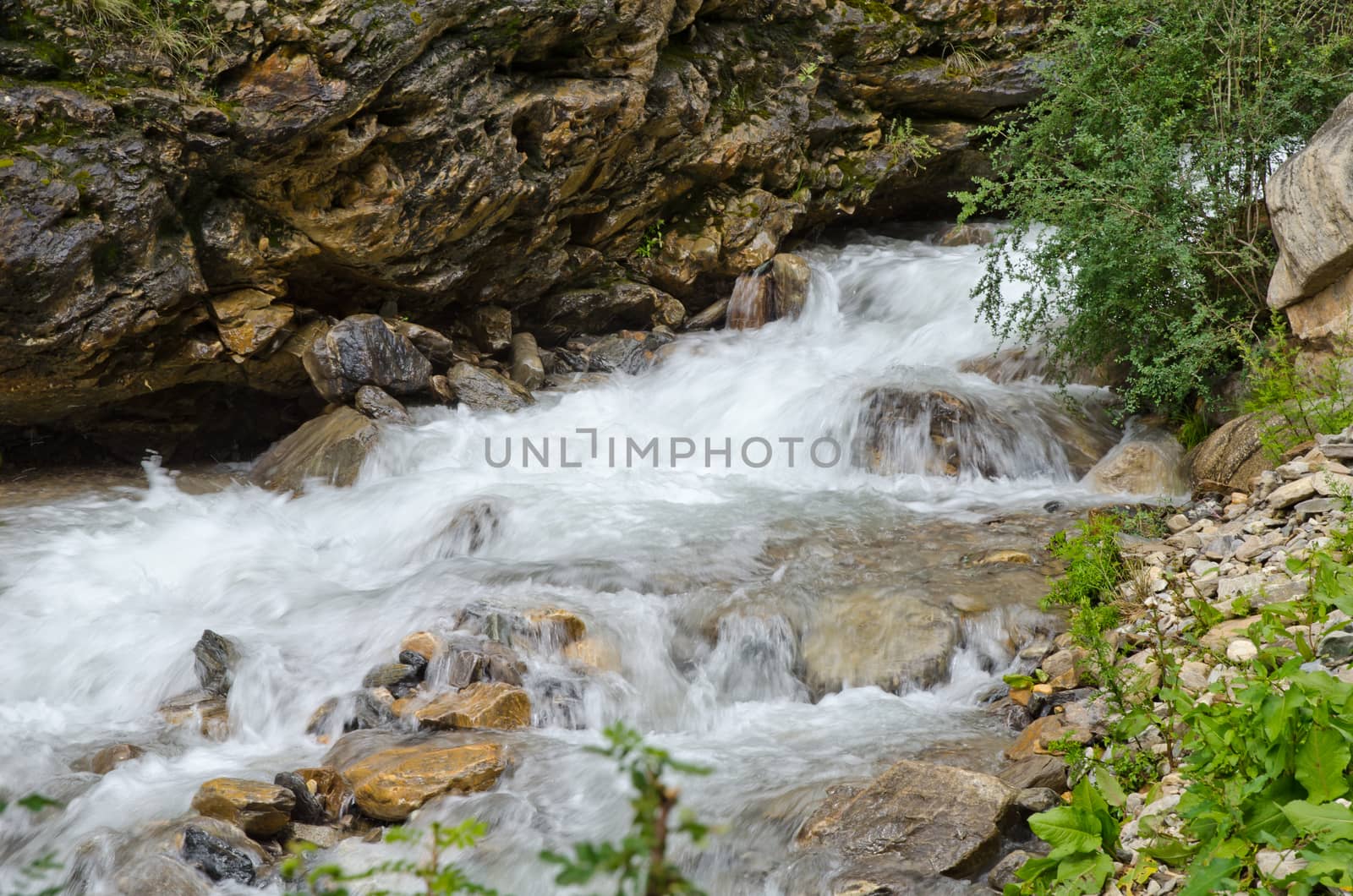 Fast, affluent and muddy mountain Tibetan river (blurred motion)