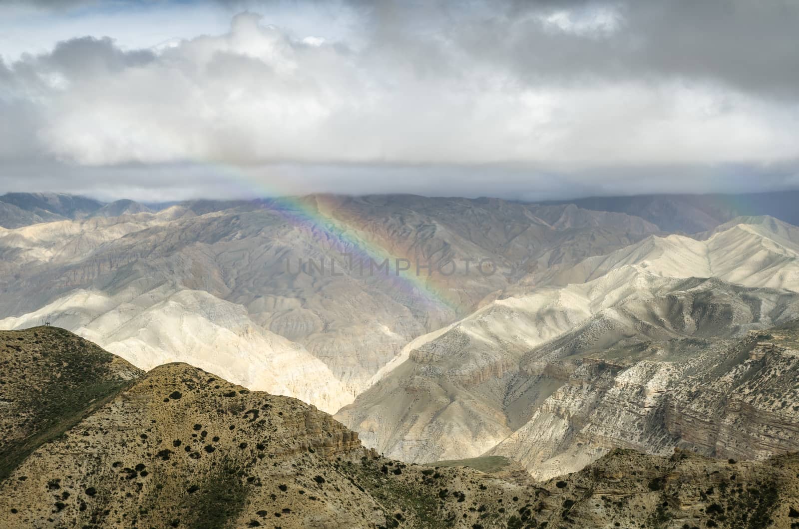 Real-colored rainbow in the high mountain sky after the distant rain along the route from Samar to Gemi villages of Upper Mustang, Nepal