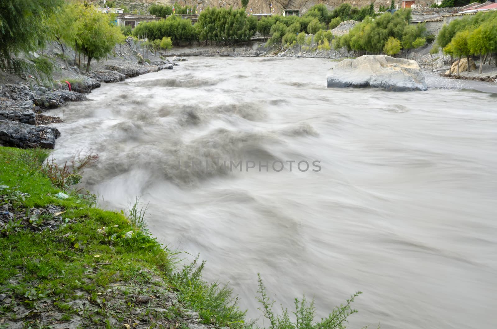 Fast, affluent and muddy mountain Nepal river near Jomsom village