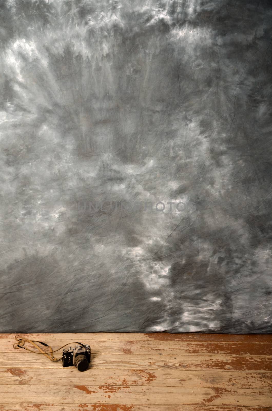 Studio background and ancient photo camera on the wooden floor