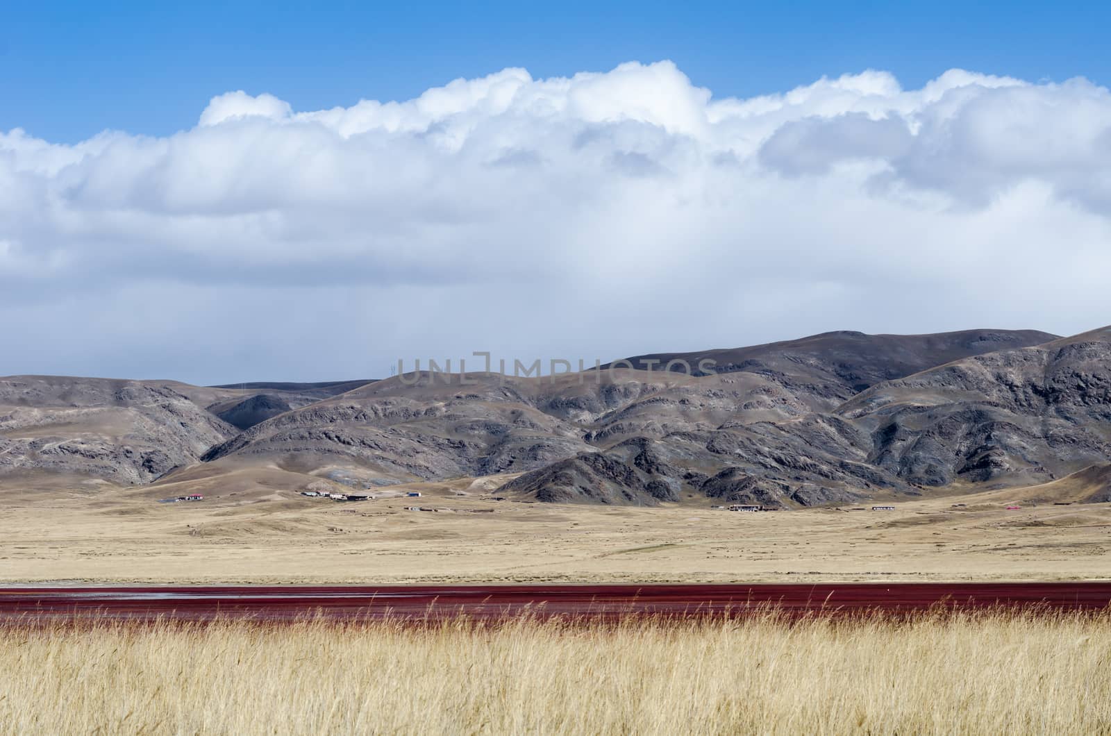 Tibetan highlands and interesting red-colored lake near Daotanghe city at Qinghai province