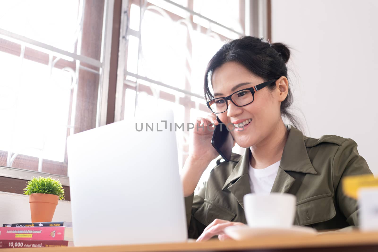 Modern young Asian woman working from home and talking with a partner about her business with happy and smile.