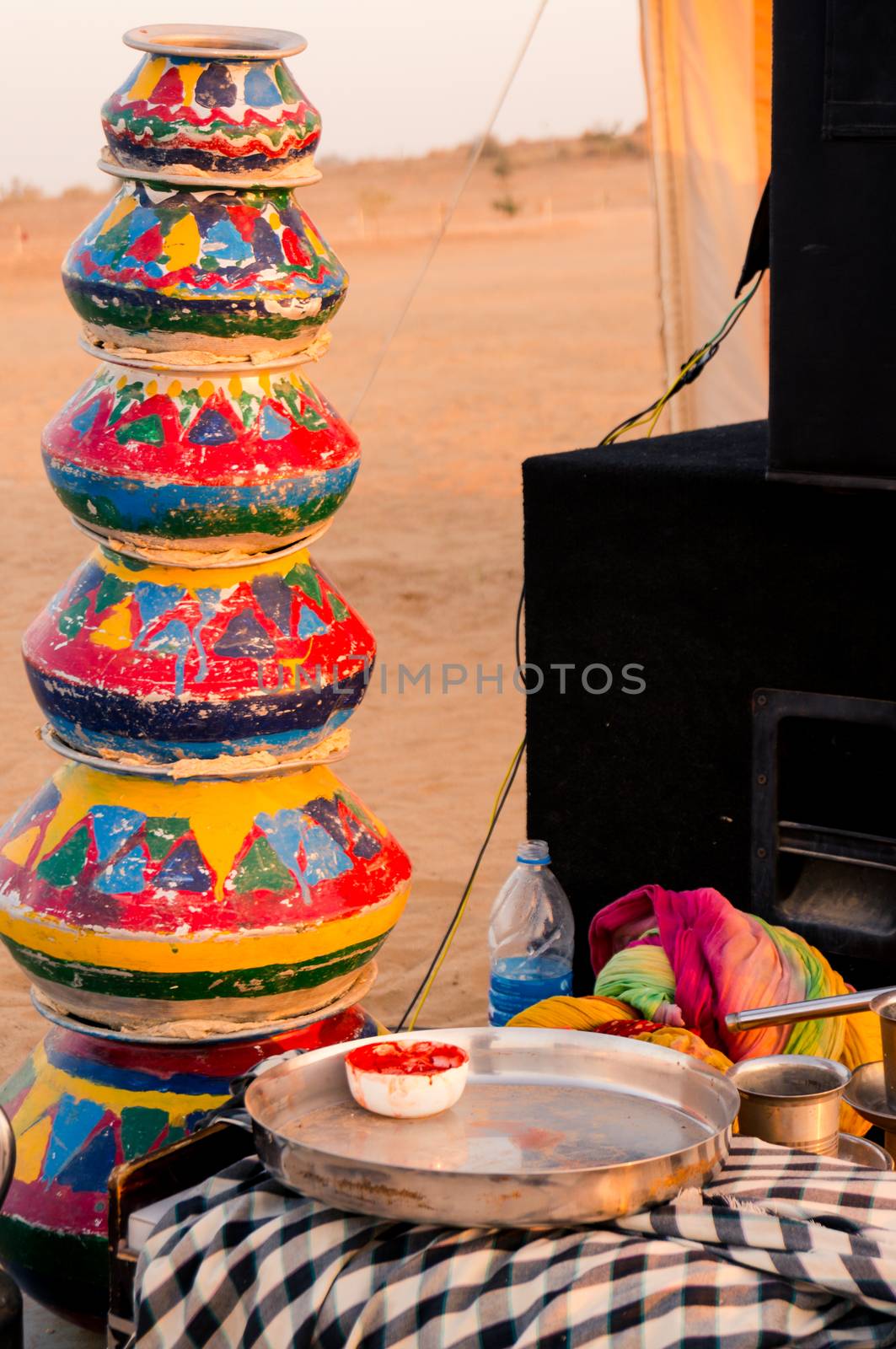 Evening shot showing the props like clayware pots, clay pots, dishes, kettle, mics and more as props for traditional rajasthani dances for visitor entertainment at a desert camp. Shows the colorful traditions of rajasthan the biggest state of India
