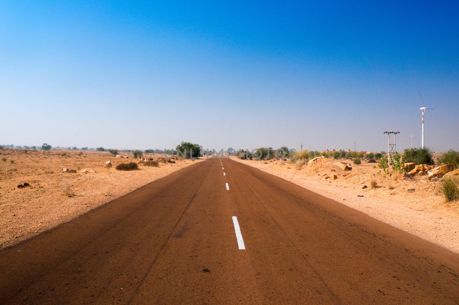 Narrow highway road with barren desert on both sides shot in Rajasthan India by Shalinimathur