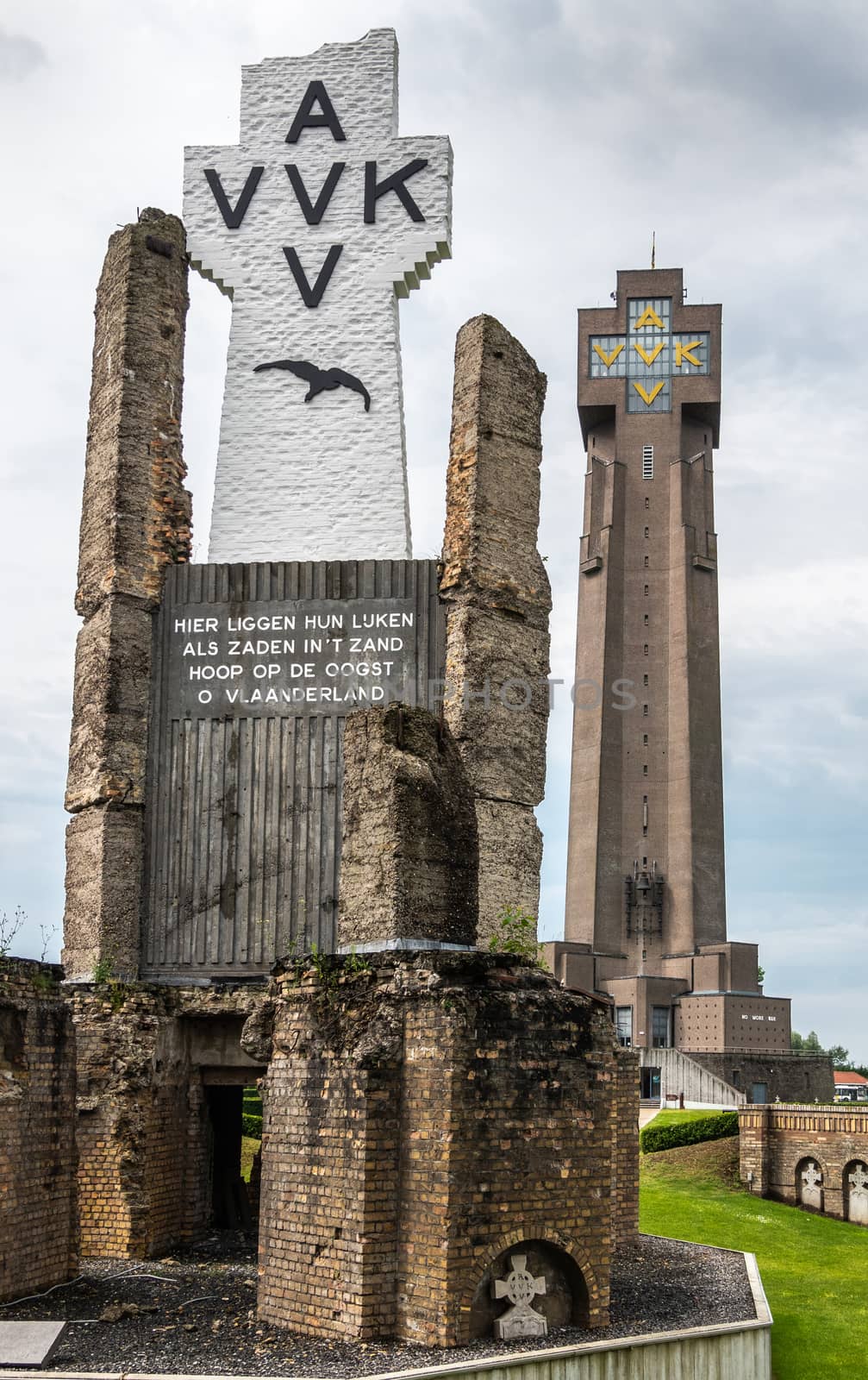 Diksmuide, Flanders, Belgium -  June 19, 2019: Black on White Crypt memorial, remnants of dynamited tower, and new IJzertoren, tallest peace monument of WW 1 against gray cloudscape.