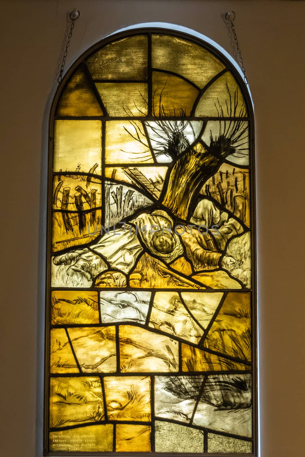 Diksmuide, Flanders, Belgium -  June 19, 2019: Yellowish Stained glass window in chapel of IJzertoren, depicting dead brothers Van Raemdonck, Flemish iconic soldiers.