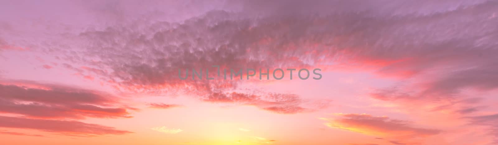 Cloudy sky at sunset or sunrise with sunlight. Abstract backdrop for design.