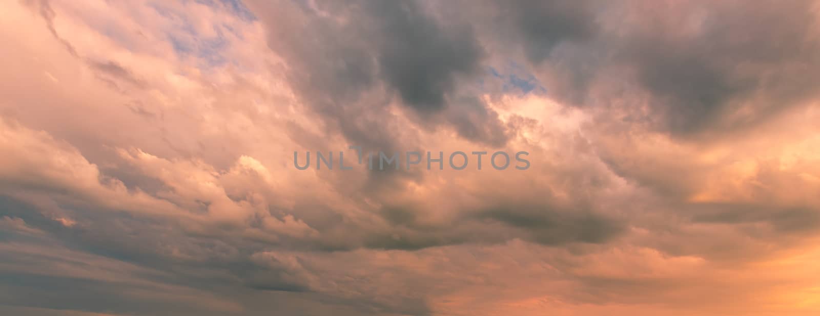 Cloudy sky at sunset or sunrise with sunlight. Abstract background for design.