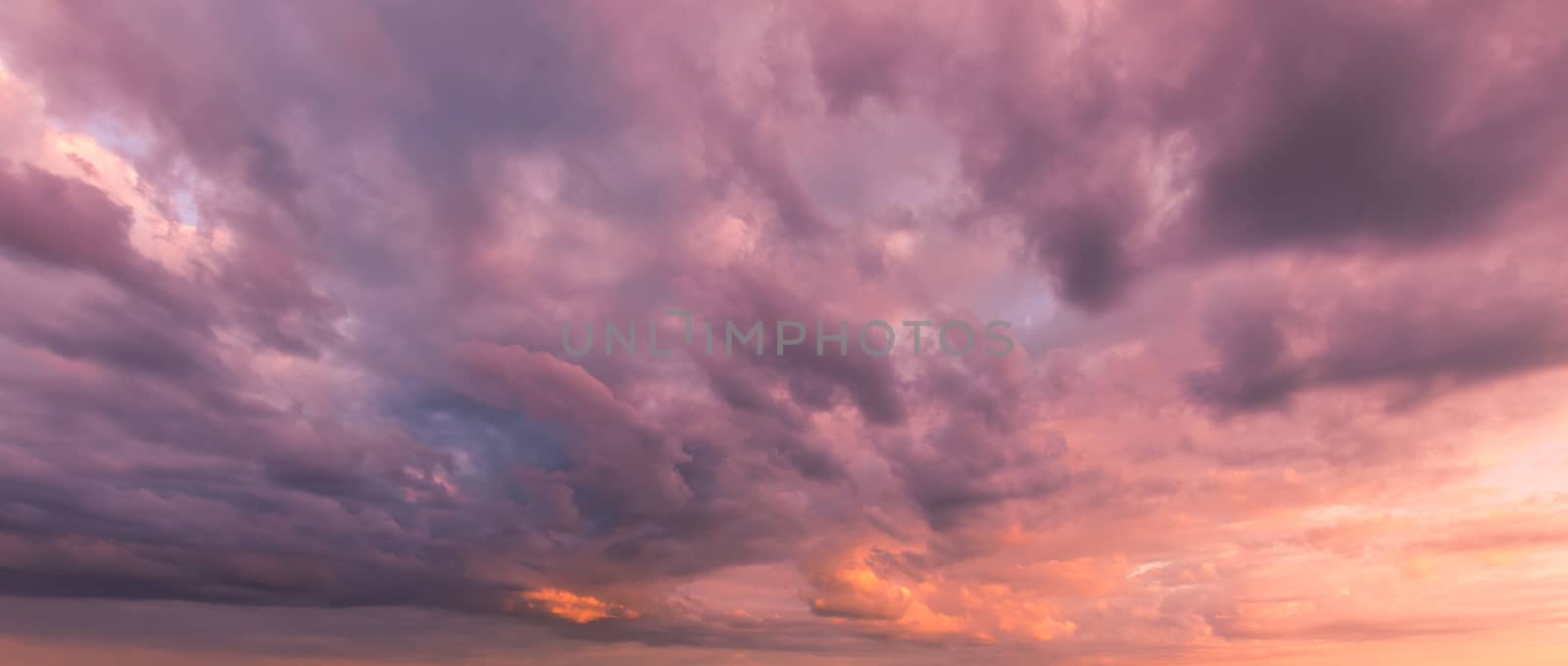 Cloudy sky at sunset or sunrise with sunlight. Abstract background for design.