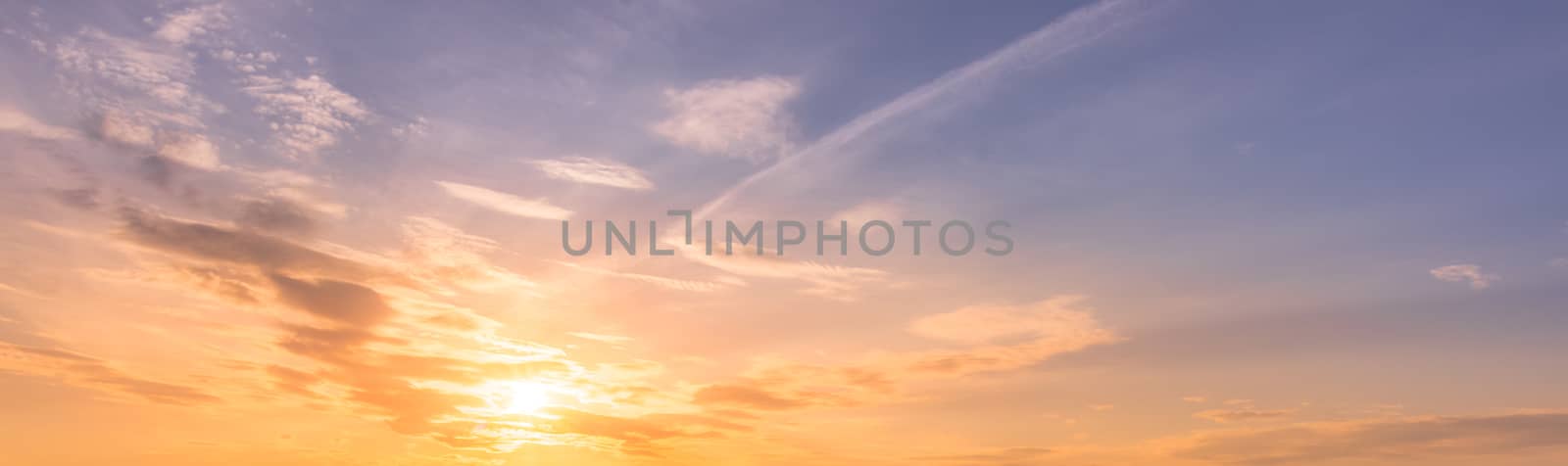 Cloudy sky at sunset or sunrise with bright sun. Abstract background for design.