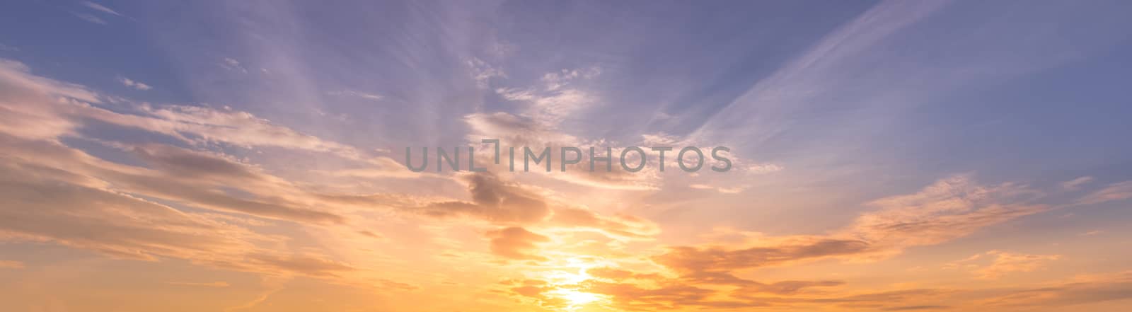 Cloudy sky at sunset or sunrise with bright sun. Abstract background for design.