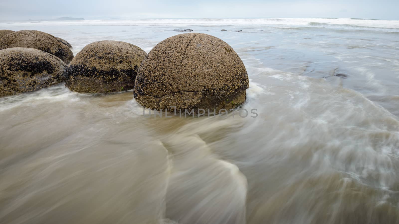 Moeraki boulders in the blurred Pacific Ocean waves by nemo269