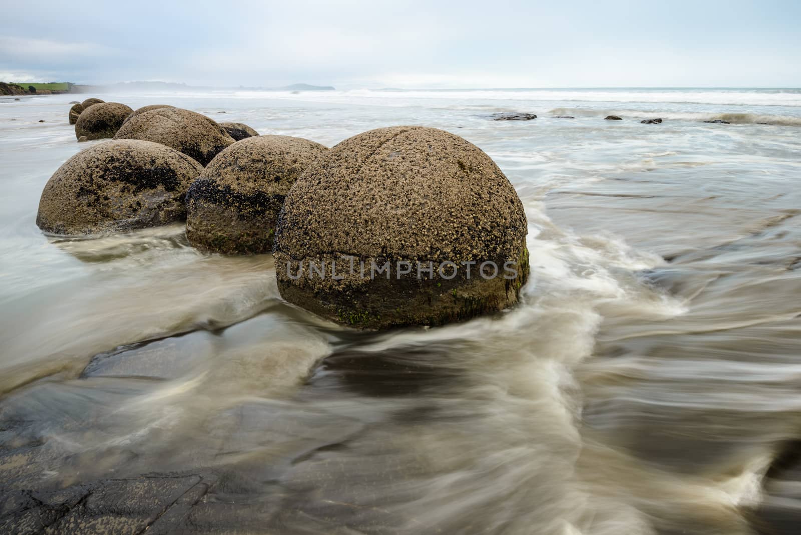 Impressive Moeraki boulders in the blurred Pacific Ocean waves by nemo269