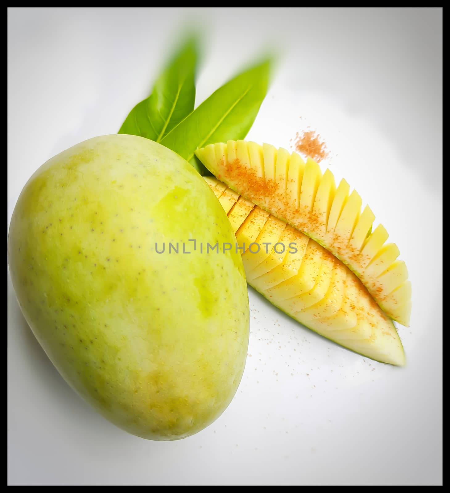 One mango and its slices of mango beautifully arranged in white plate with its leaf nd summer fruit and good for health also