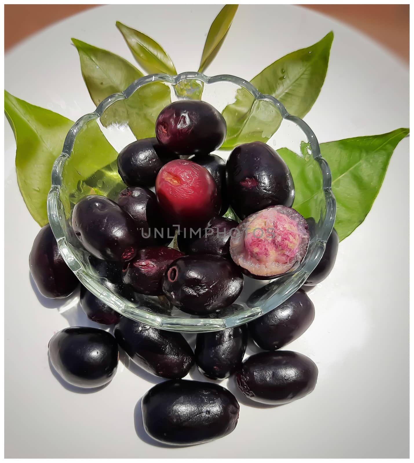Black plum in bowl decorated beautifully with its leaves contains vitamin C and iron hemoglobin heart healthy and treats diabetes summer season fruit