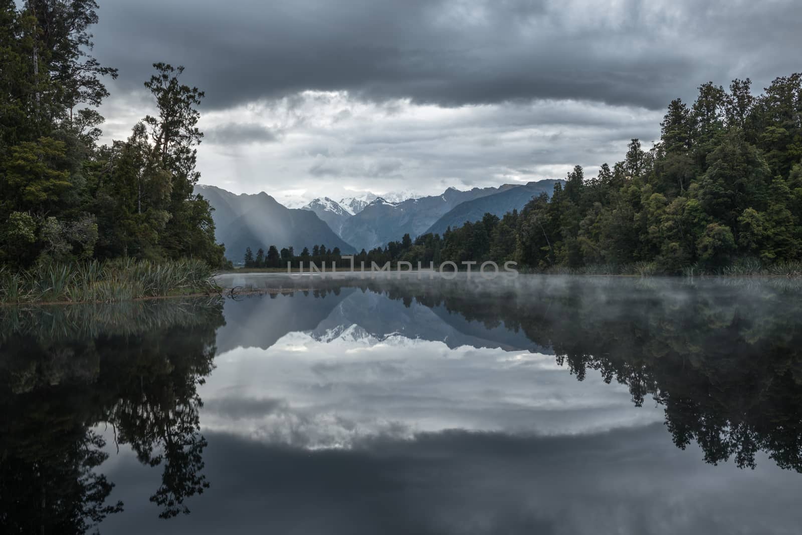 Distant snowy mountain is reflected in the Lake Matheson water by nemo269