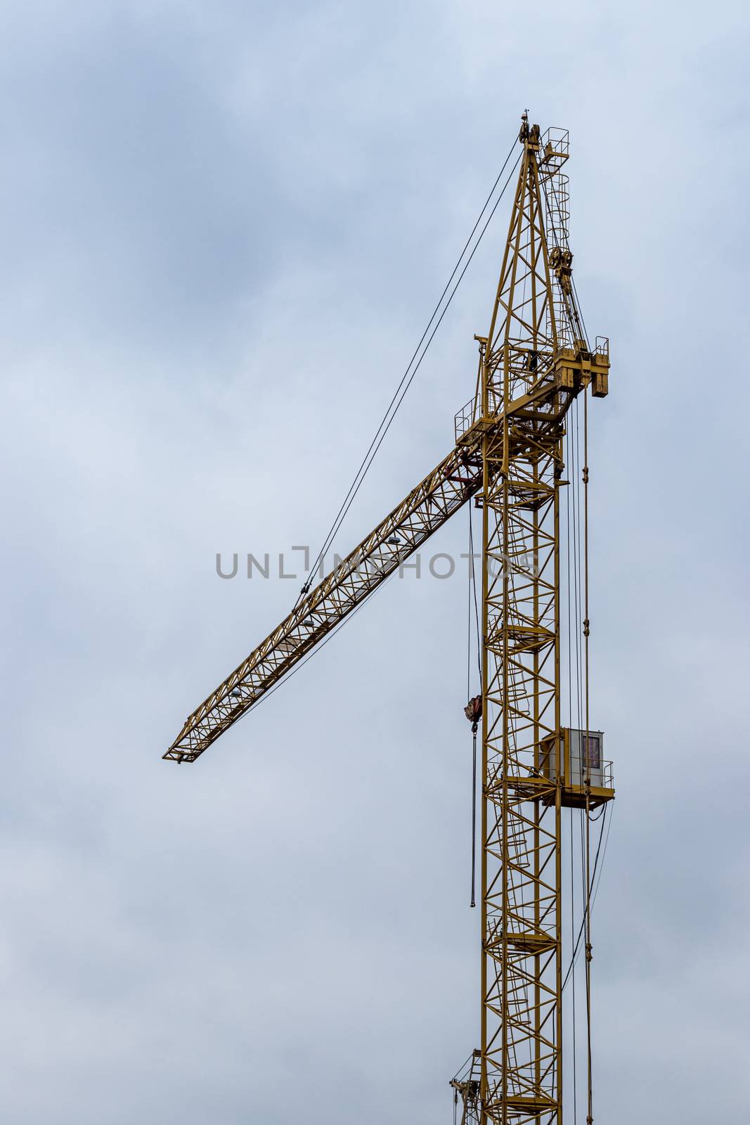 Boom crane on a background of cloudy cloudy sky.
