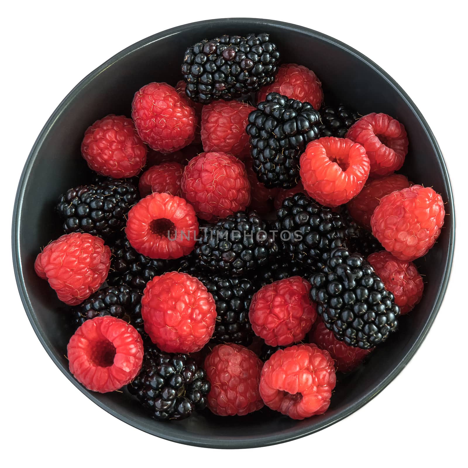 Blackberries and raspberries in a black bowl. White background. Top view.