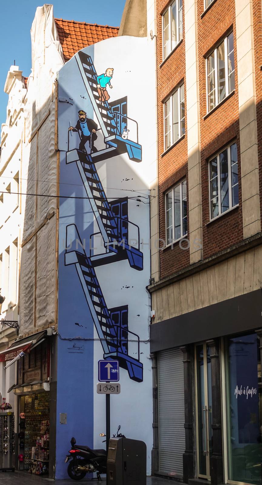 Brussels, Belgium - June 22, 2019: Tintin themed blue-white wall painting of stairway on side facade of house in Rue de l’Etuve.
