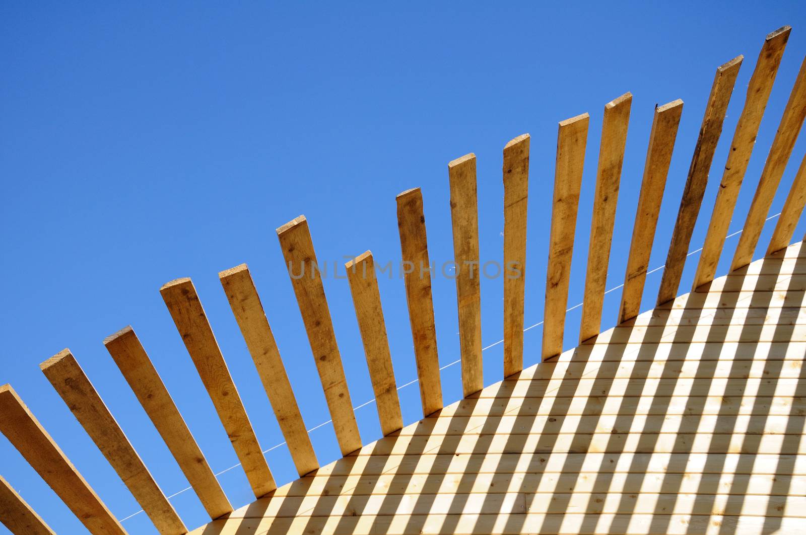 The unfinished wooden roof at the blue sky