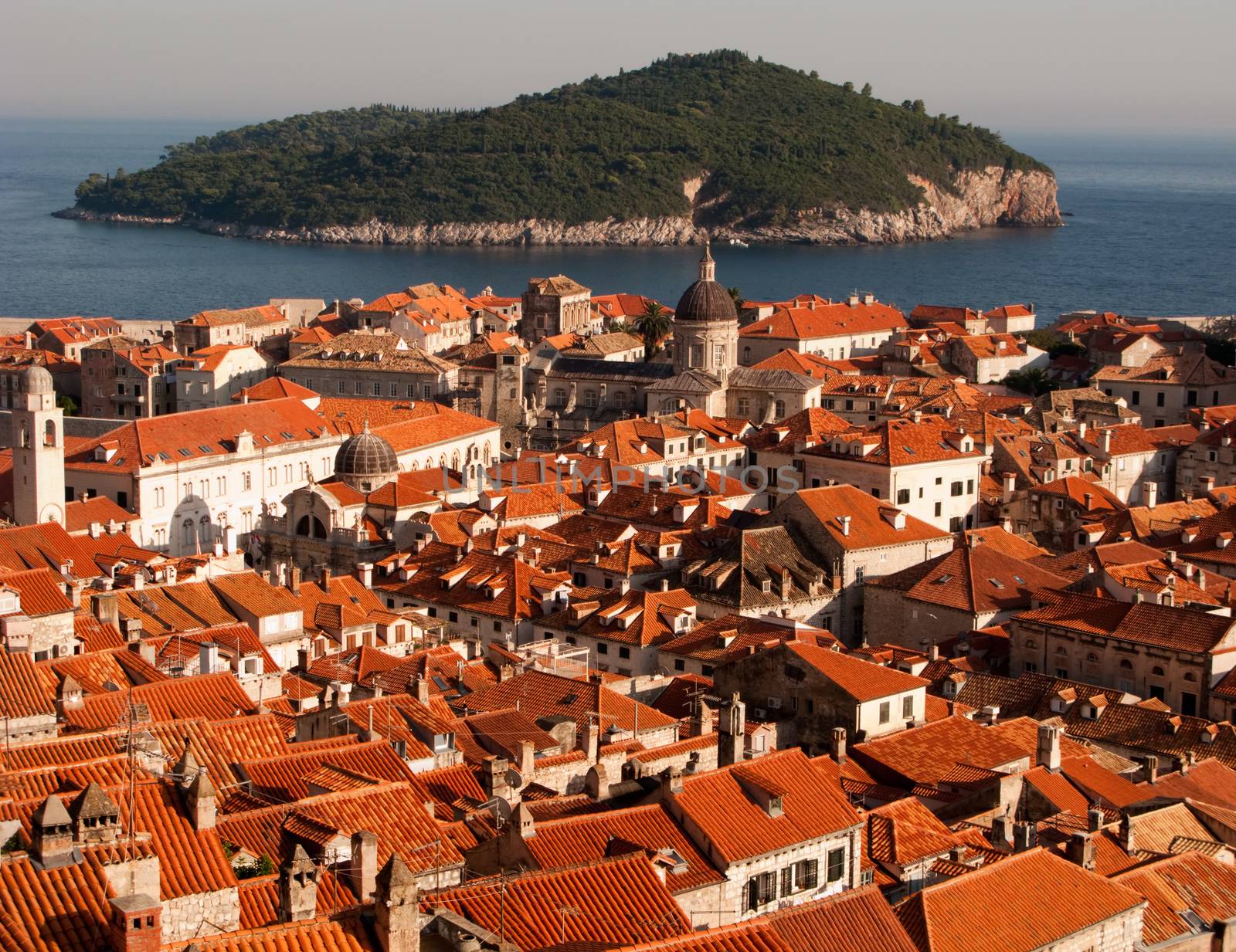 This is a picture ot Dubrovnik red and orange roofs and distant island behind.