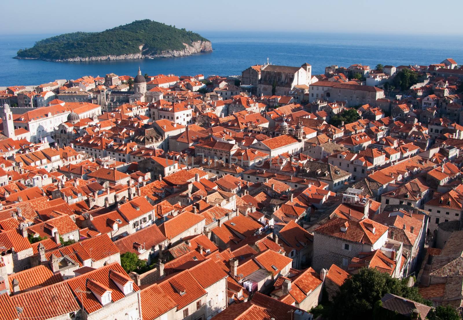 This is a picture of red and orange roofs and distant island behind. Dubrovnik, Croatia.