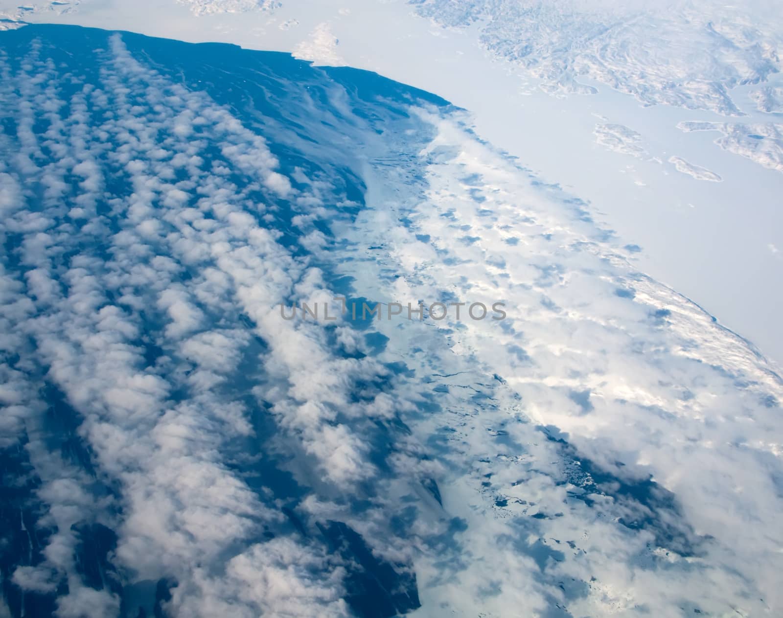 Aerial view of the Greenland coastline with ocean and clouds