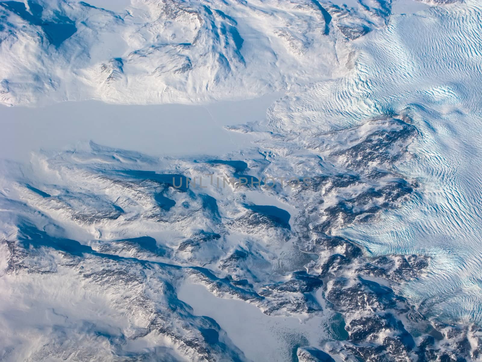 Aerial view of the Greenland with mountain, snow river and waves
