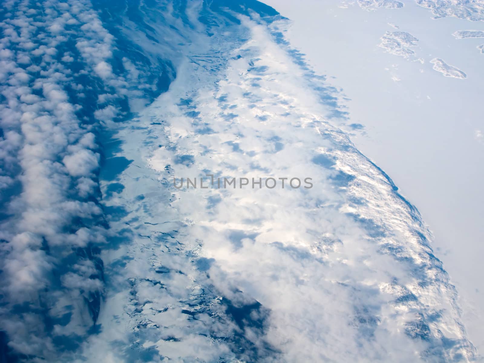 Aerial view of the Greenland coastline with ocean and clouds