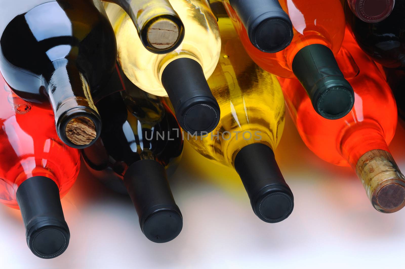 Closeup of a group of assorted wine bottles laying on their side.