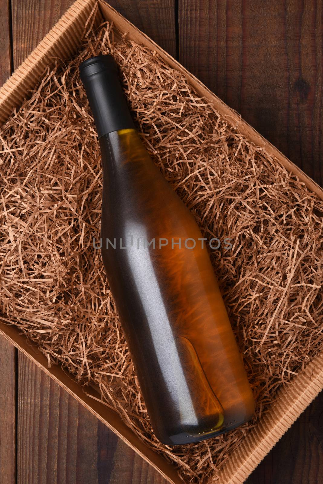Chardonnay Wine Bottle in Packing Straw: High angle shot of a single bottle in a cardboard box with straw packing.