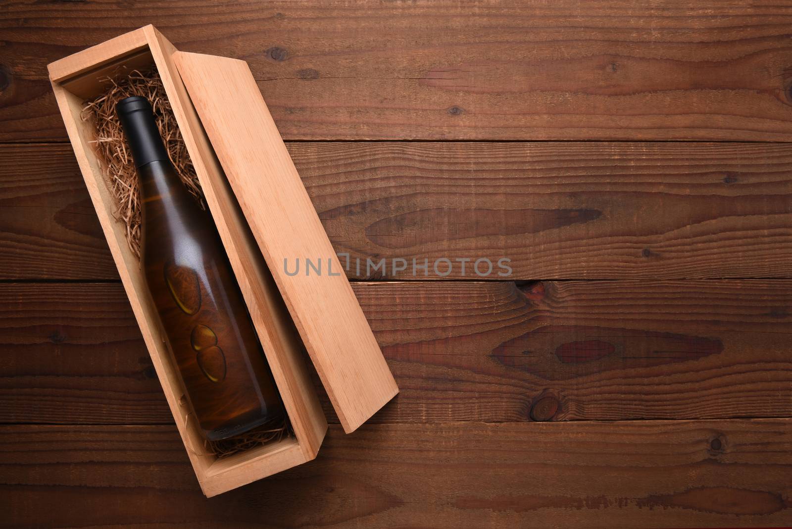 Chardonnay Wine Box: A single Bottle of Chardonnay wine in its wooden case on a dark wood table with copy space.