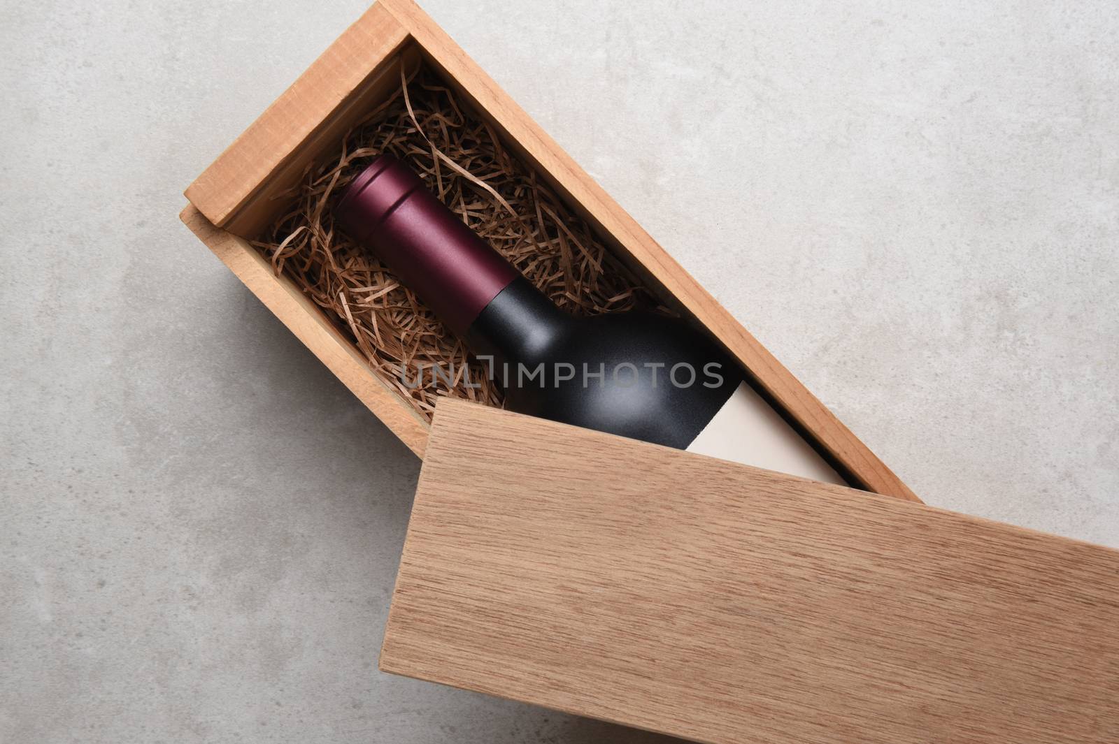 A single bottle of red wine in a wood box by sCukrov